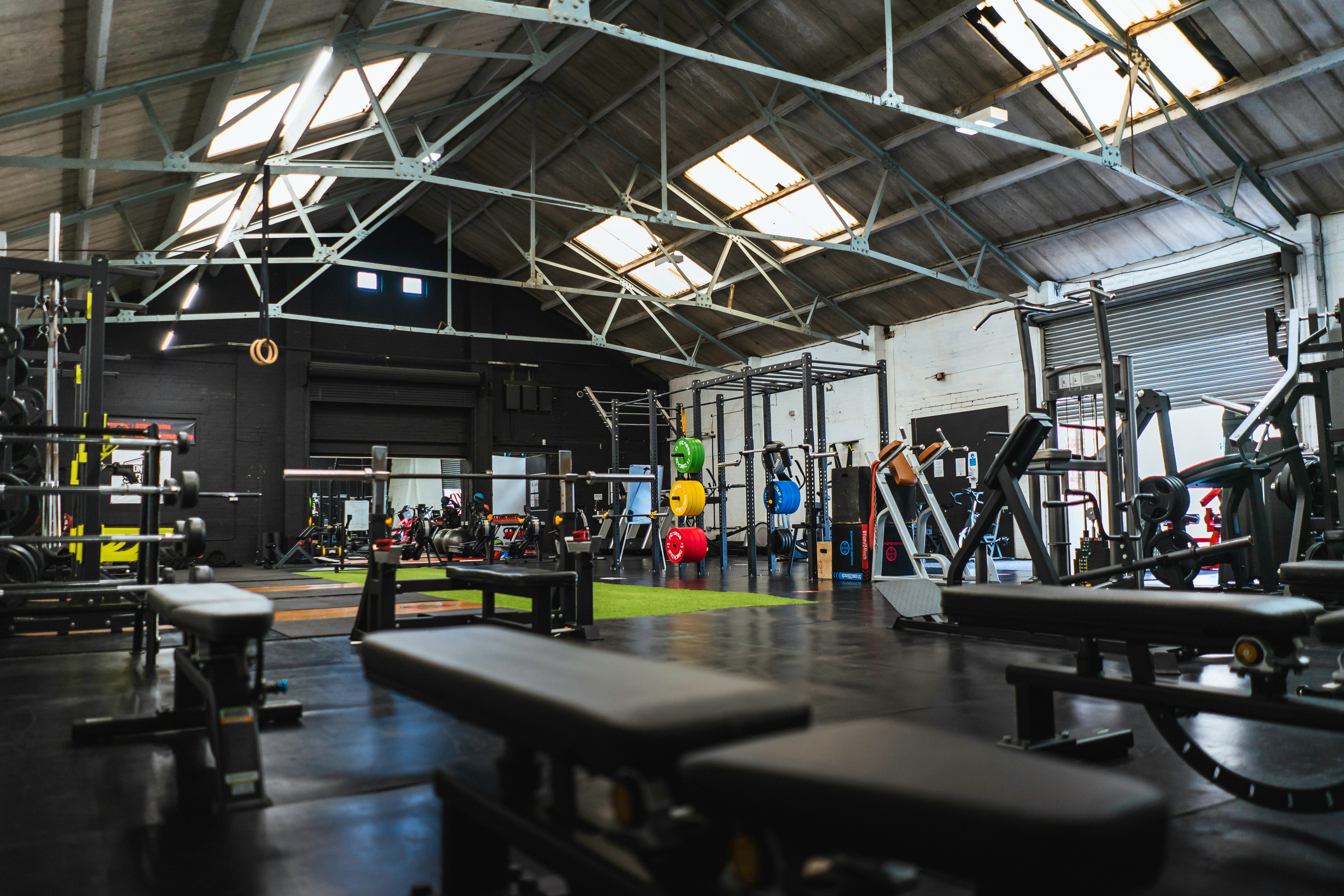 A modern gym facility equipped with diverse workout stations and colorful weight plates, symbolizing the versatility and variety required for effective training routines.