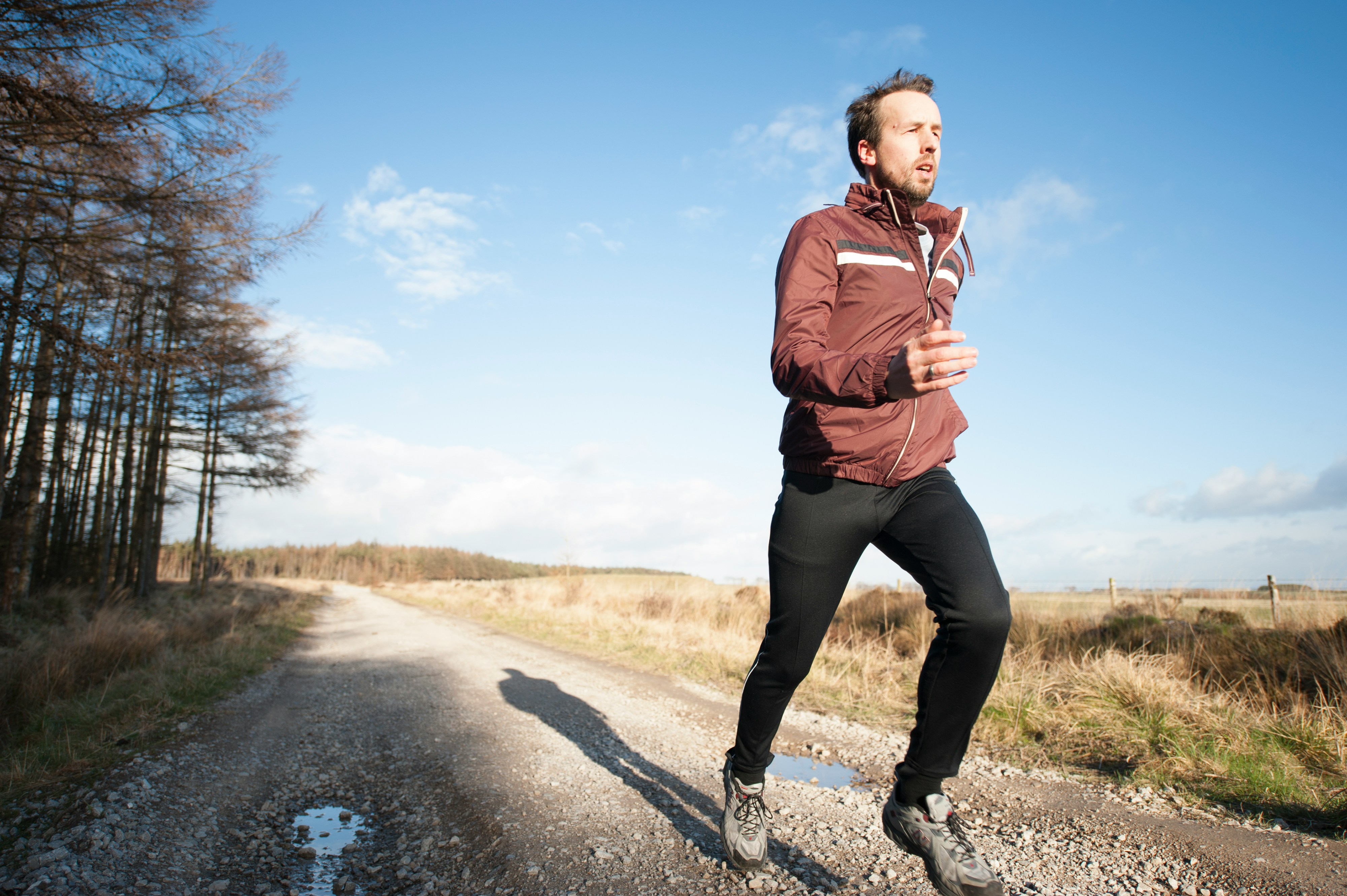 An athlete running on a scenic trail, showcasing the impact of outdoor and dynamic training methods for improved endurance and fitness.